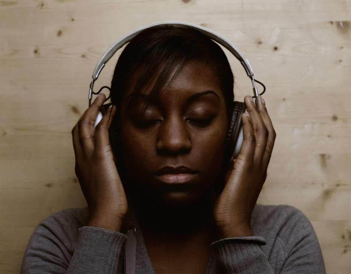 woman wearing headphones whilst relaxing to new music