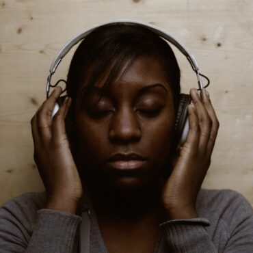 woman wearing headphones whilst relaxing to new music